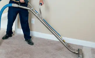 Professional operating a liquid removal machine on a carpeted floor in Tampa, FL